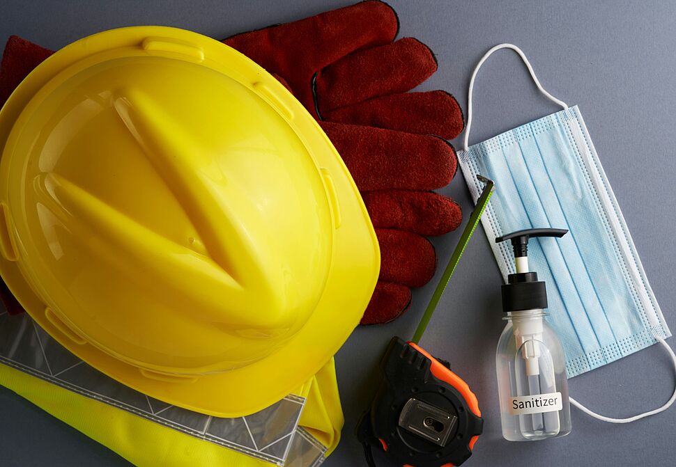 Schutzausrüstung wie Helm,Handschuhe,Mundschutz,Handdesinfektion auf einem Tisch