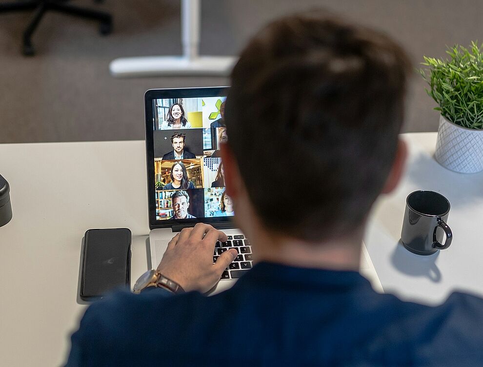 Mann sitzt vor einem Laptop