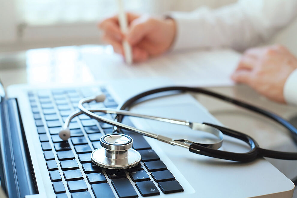 Stethoskop auf einer Laptop-Tastatur als Symbol für Arbeitsmedizin und ärztliche Fortbildung