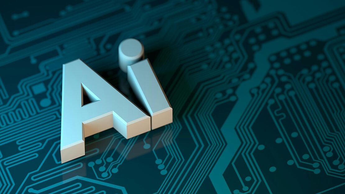 Weiße Buchstaben „AI“ auf einer Leiterplatte als Symbol für den Einsatz künstlicher Intelligenz im Arbeitsalltag sowie im Arbeits- und Brandschutz.