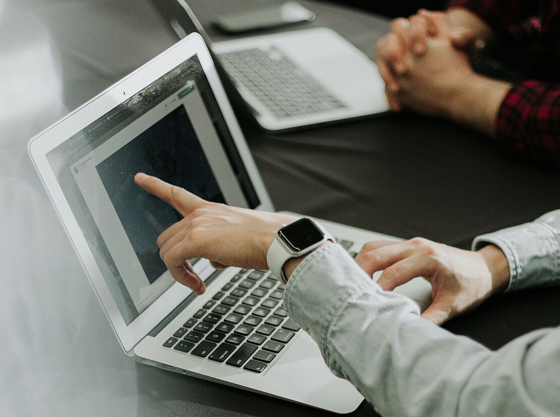 Personen besprechen digitale Unterlagen am Laptop als Symbol für Dokumentation, Verantwortung und rechtssichere Organisation im Arbeits- und Umweltschutz.