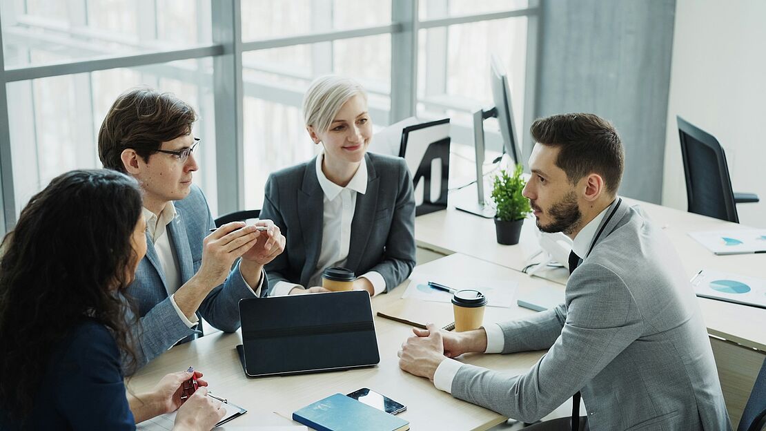 Arbeitsgruppe in einem hellen Büro, die gemeinsam Konzepte zur nachhaltigen Unternehmenspraxis und langfristigen Ressourcenschonung erarbeitet